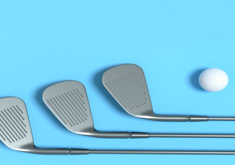 Golf clubs and ball on blue background.